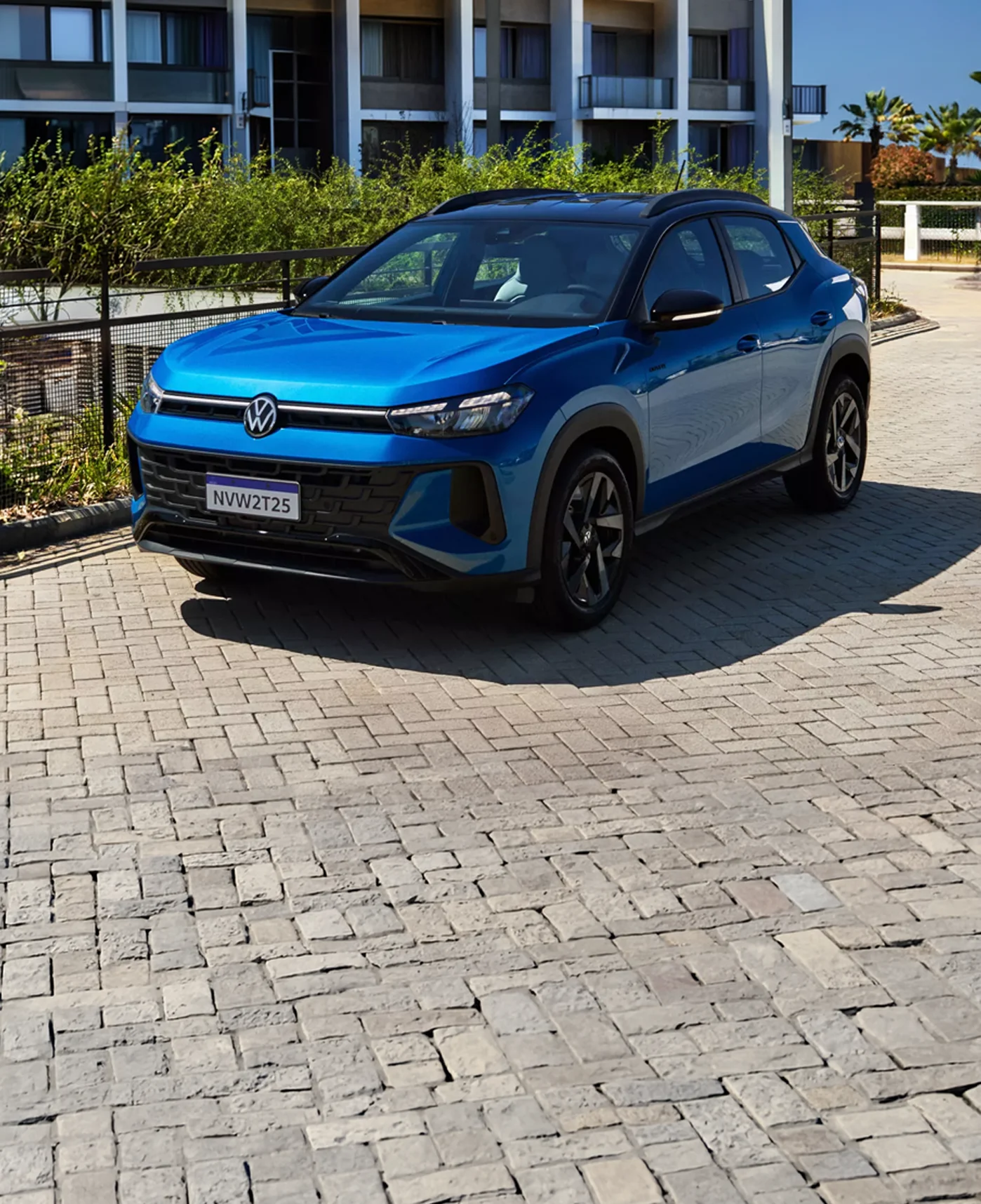 Volkswagen azul estacionado frente a un edificio